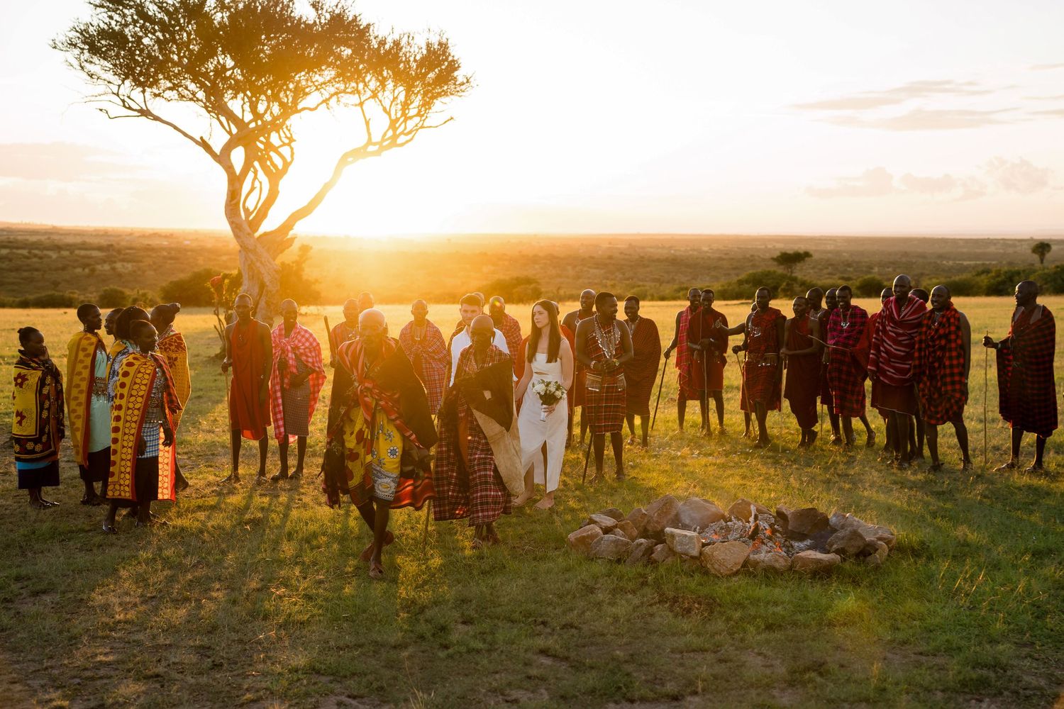 A wedding celebration with traditional African dancers and guests gathered at sunset.