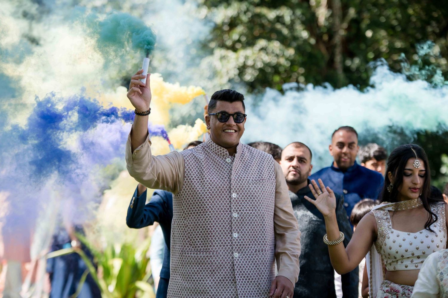 Celebration with colorful smoke bombs at an outdoor wedding event.