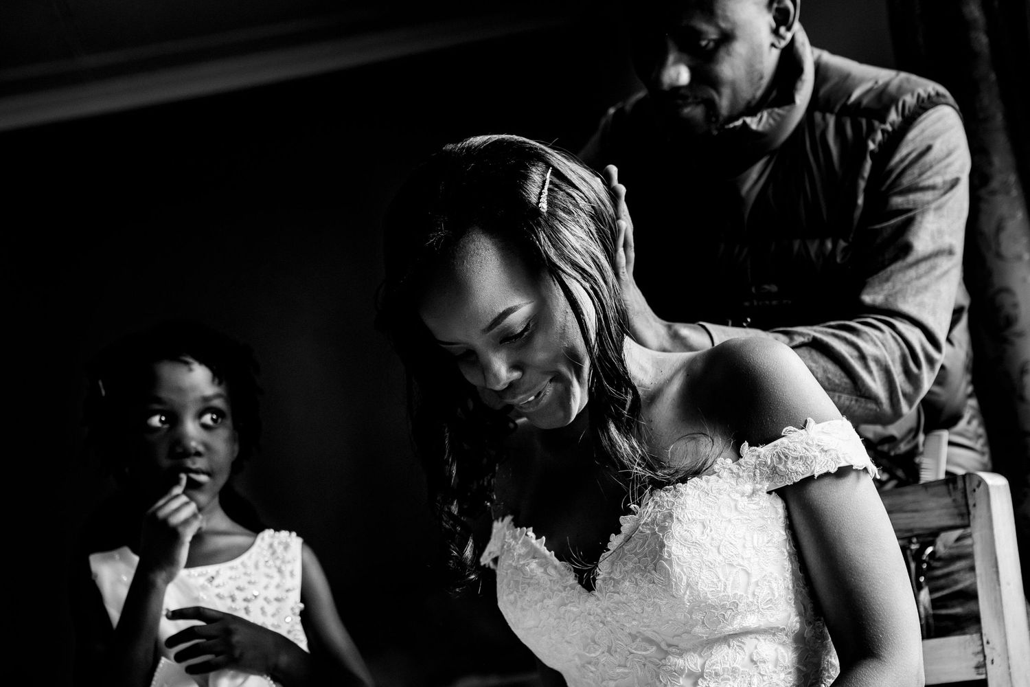 Intimate black and white moment shared between family members during wedding preparations.