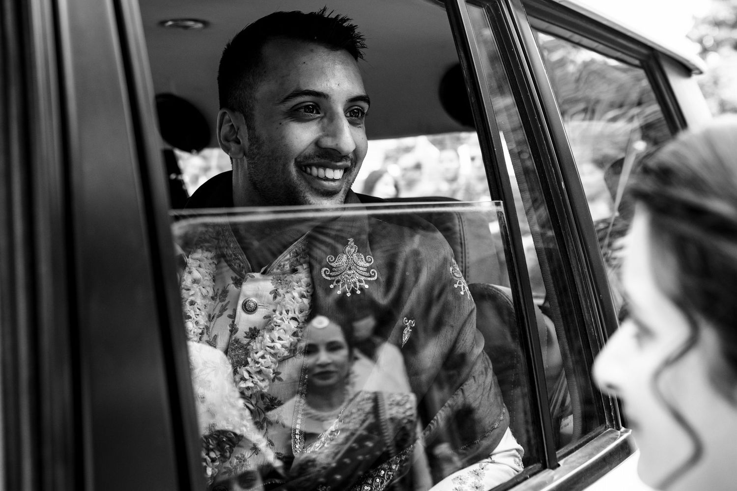 Joyful moments captured through a car window during a wedding celebration.
