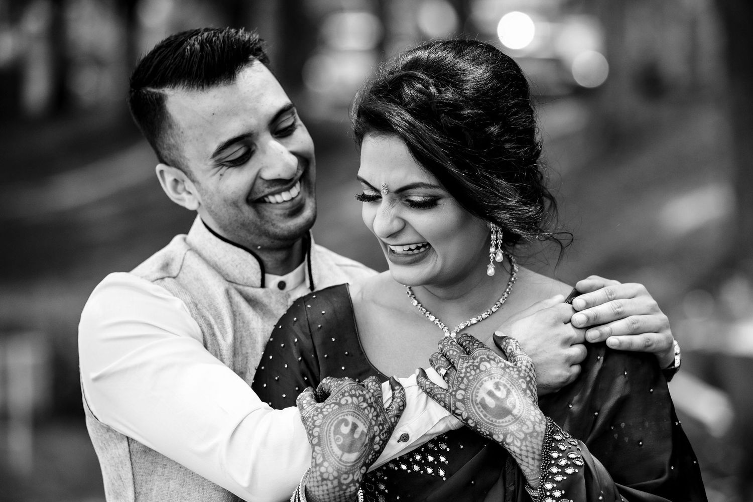 Candid black and white photo captures joyful laughter and intimate moment.