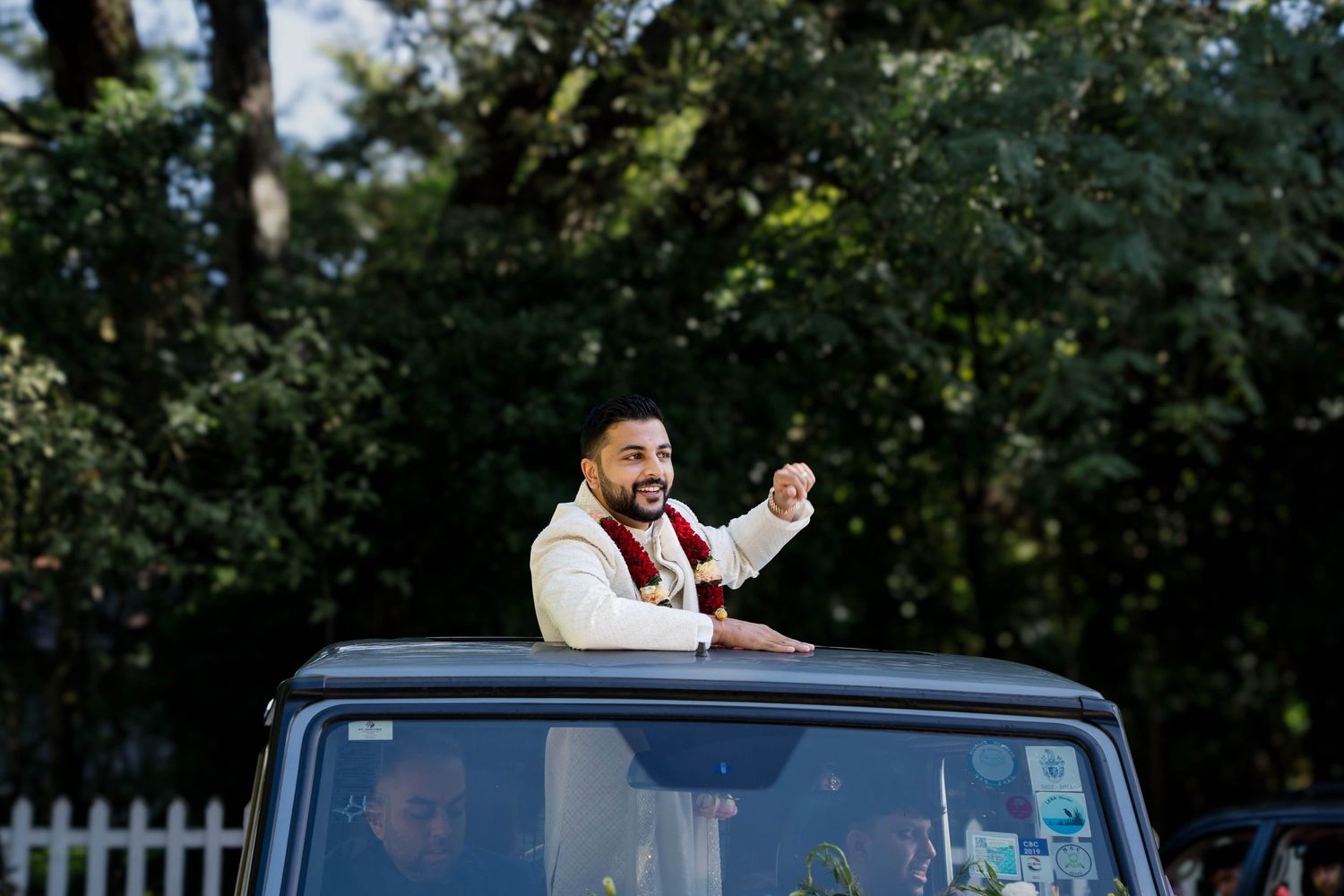 Celebratory moment captured through car window during wedding festivities.