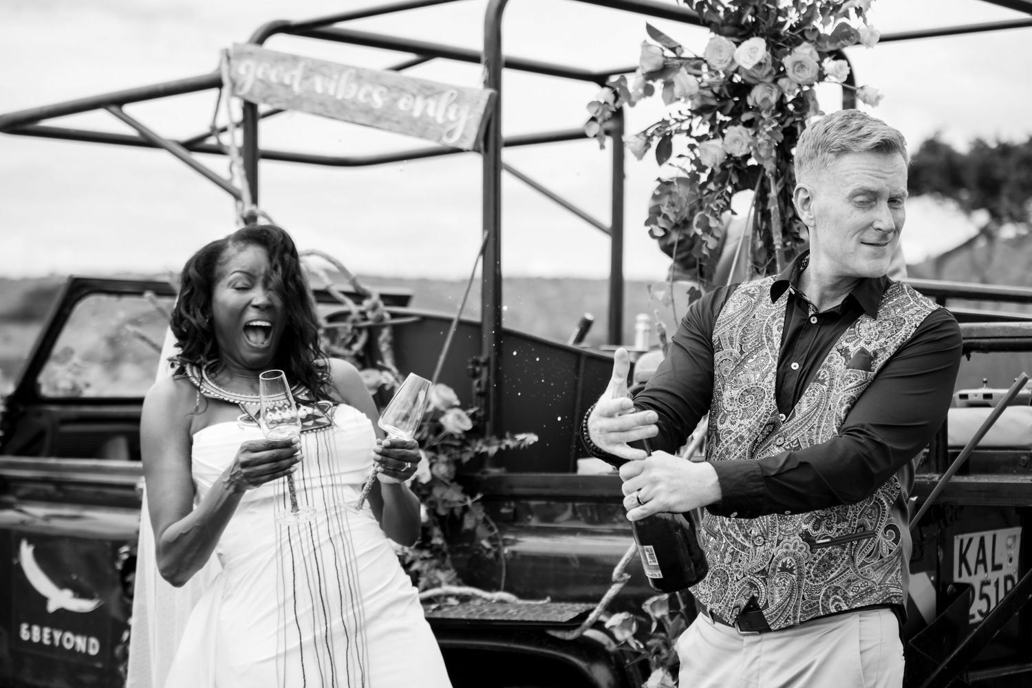Wedding celebration with decorated safari vehicle in the African grasslands.