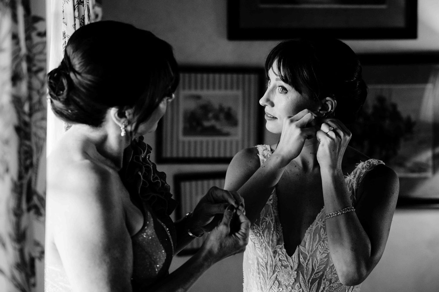 A black and white photo series showing someone applying makeup in front of a mirror in an elegant vintage setting.