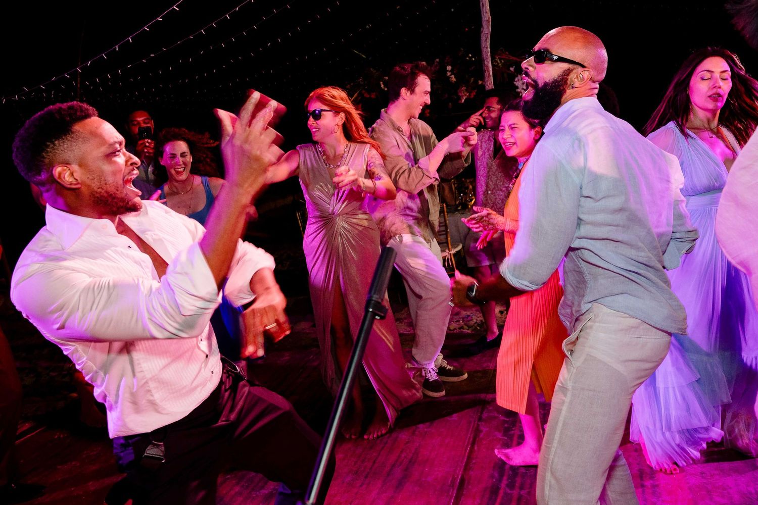 Performers dancing and singing energetically on stage during a lively musical theater performance.