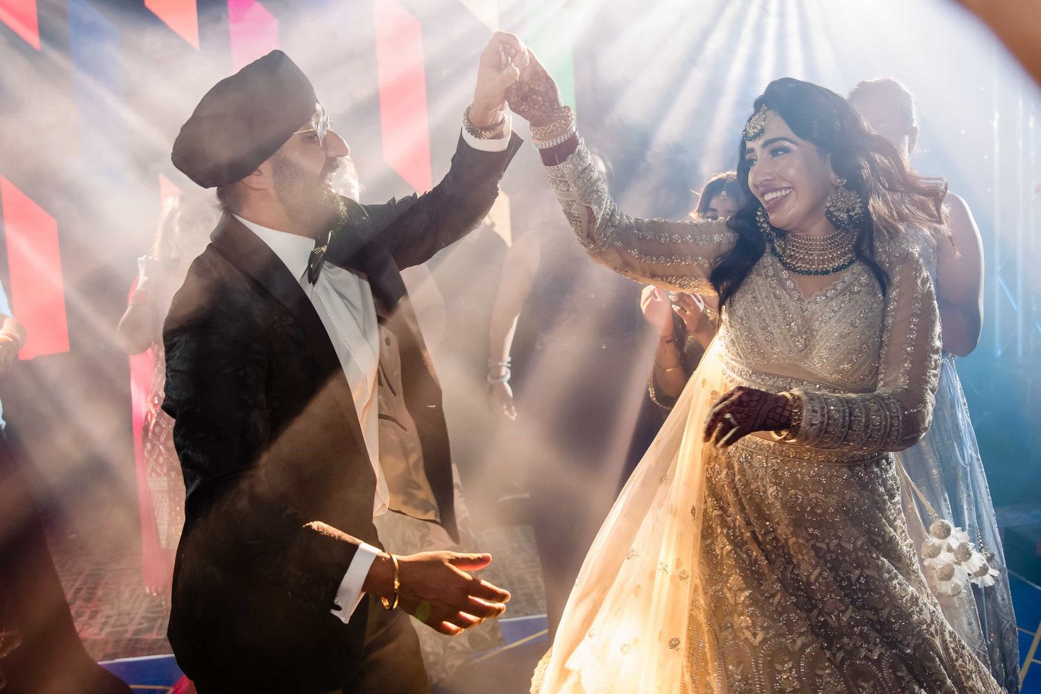 Couple dances together at their wedding reception under dramatic lighting and fog effects.