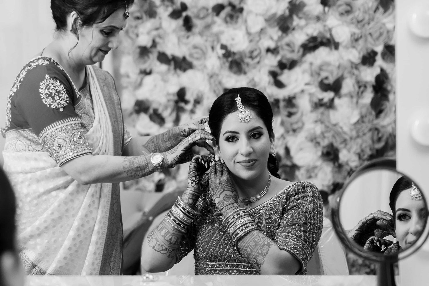 Traditional Indian bridal preparation scene with jewelry and decorative elements in black and white.