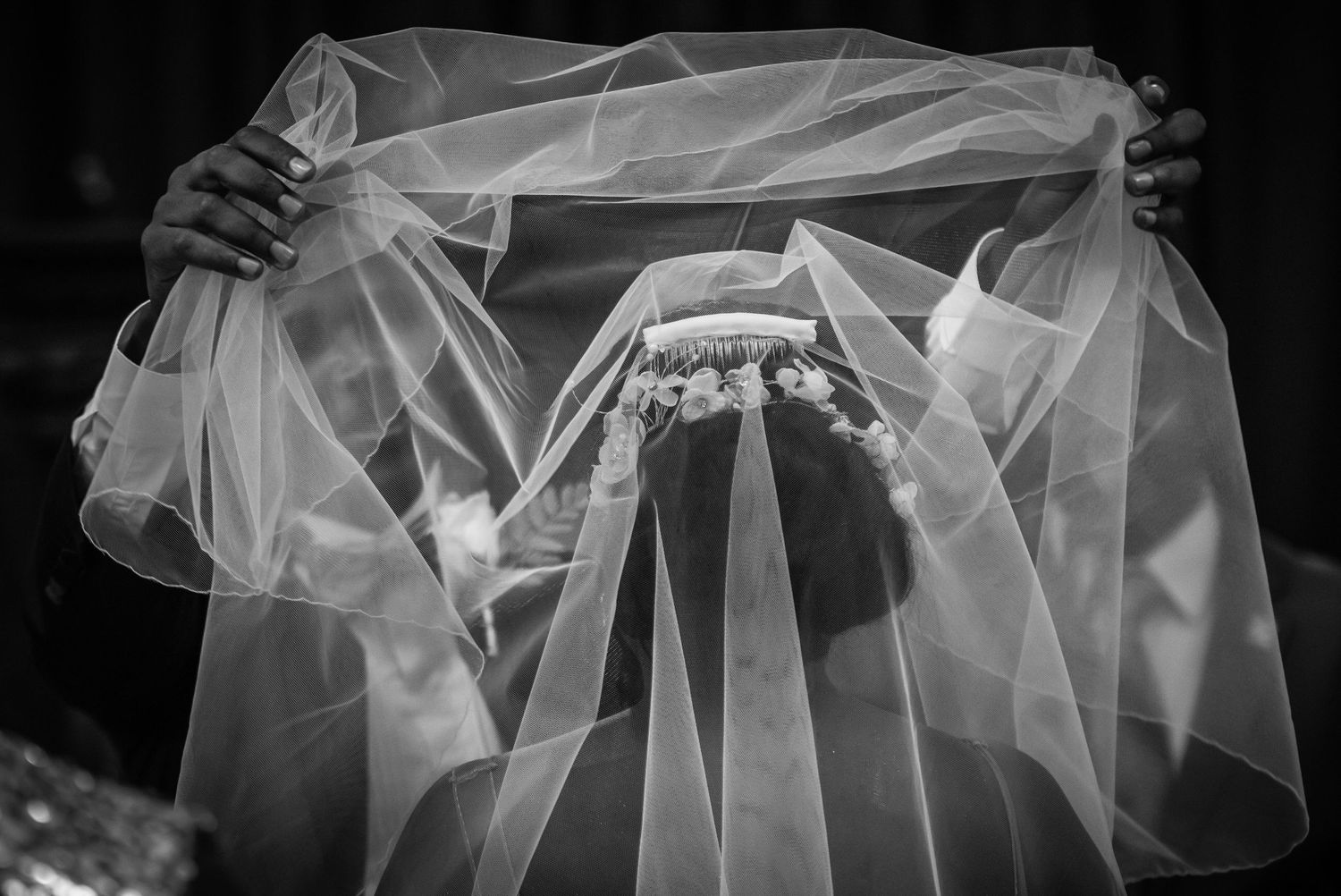 Close-up details of delicate white wedding veil fabric with soft folds and textures.