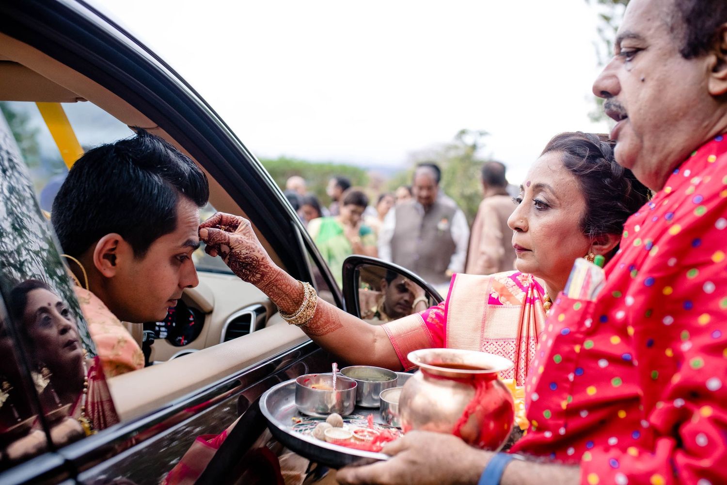 Guests looking through car windows during a traditional celebration.