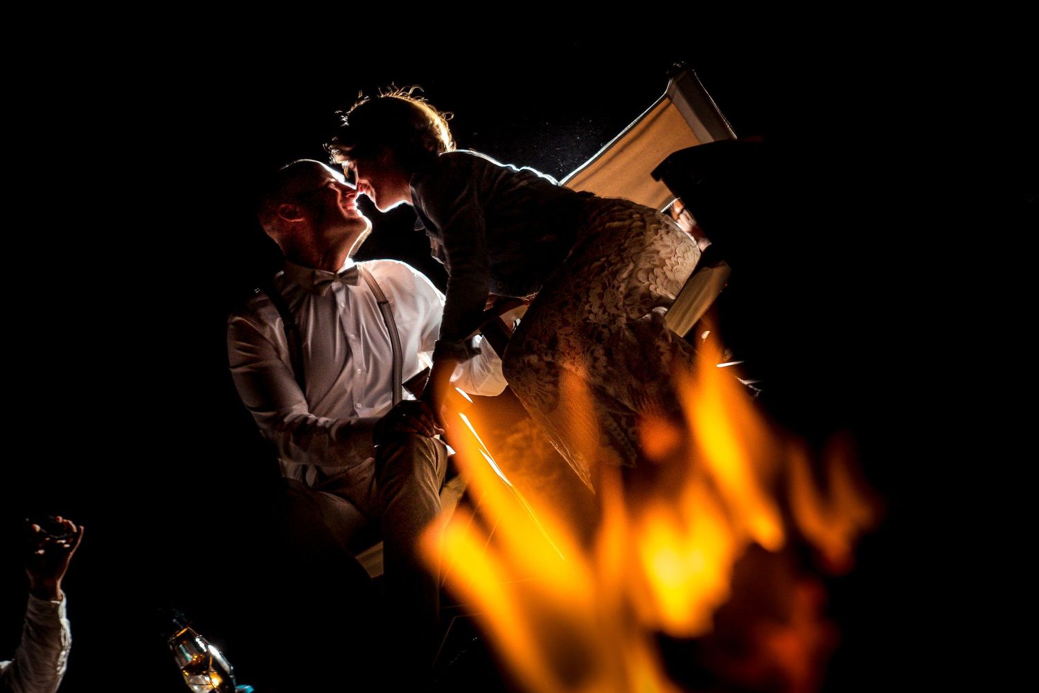 Wedding reception scene with warm firelight creating dramatic shadows and ambiance.