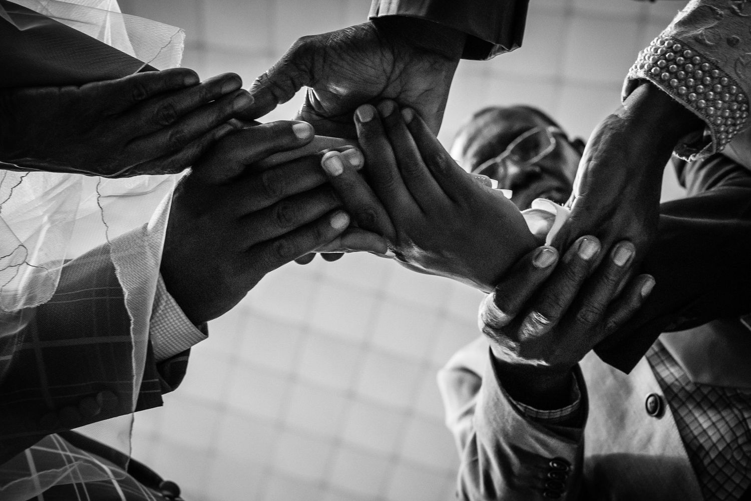 Black and white close-up of hands with delicate veil details.