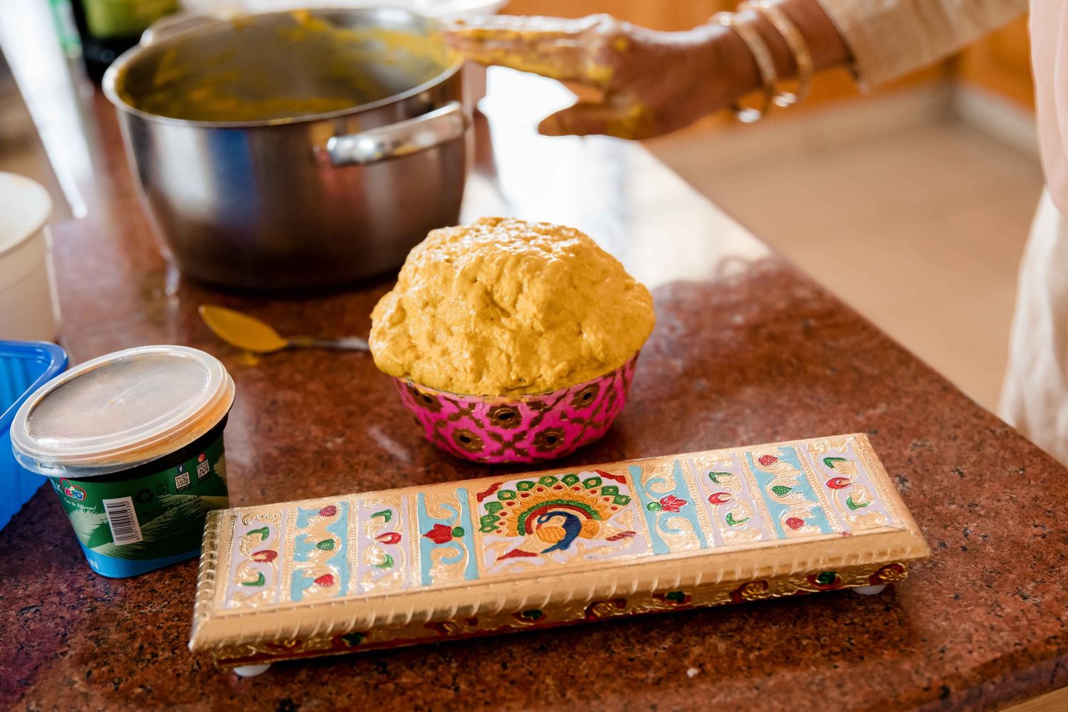 Traditional Indian game board and snack setup with yellow puri bread on table.