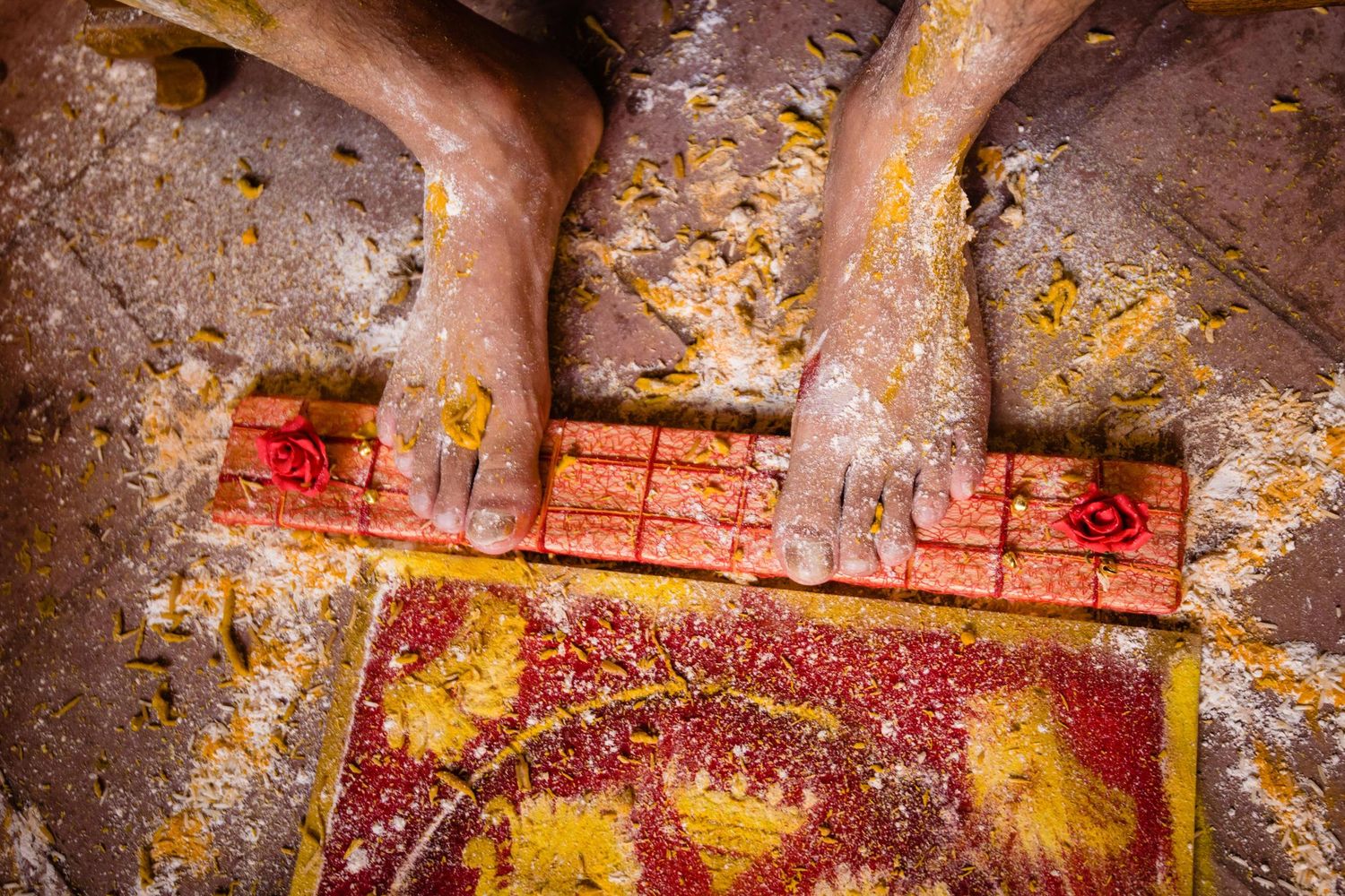 Colorful powder and paint splatters create vibrant abstract patterns on a textured surface.
