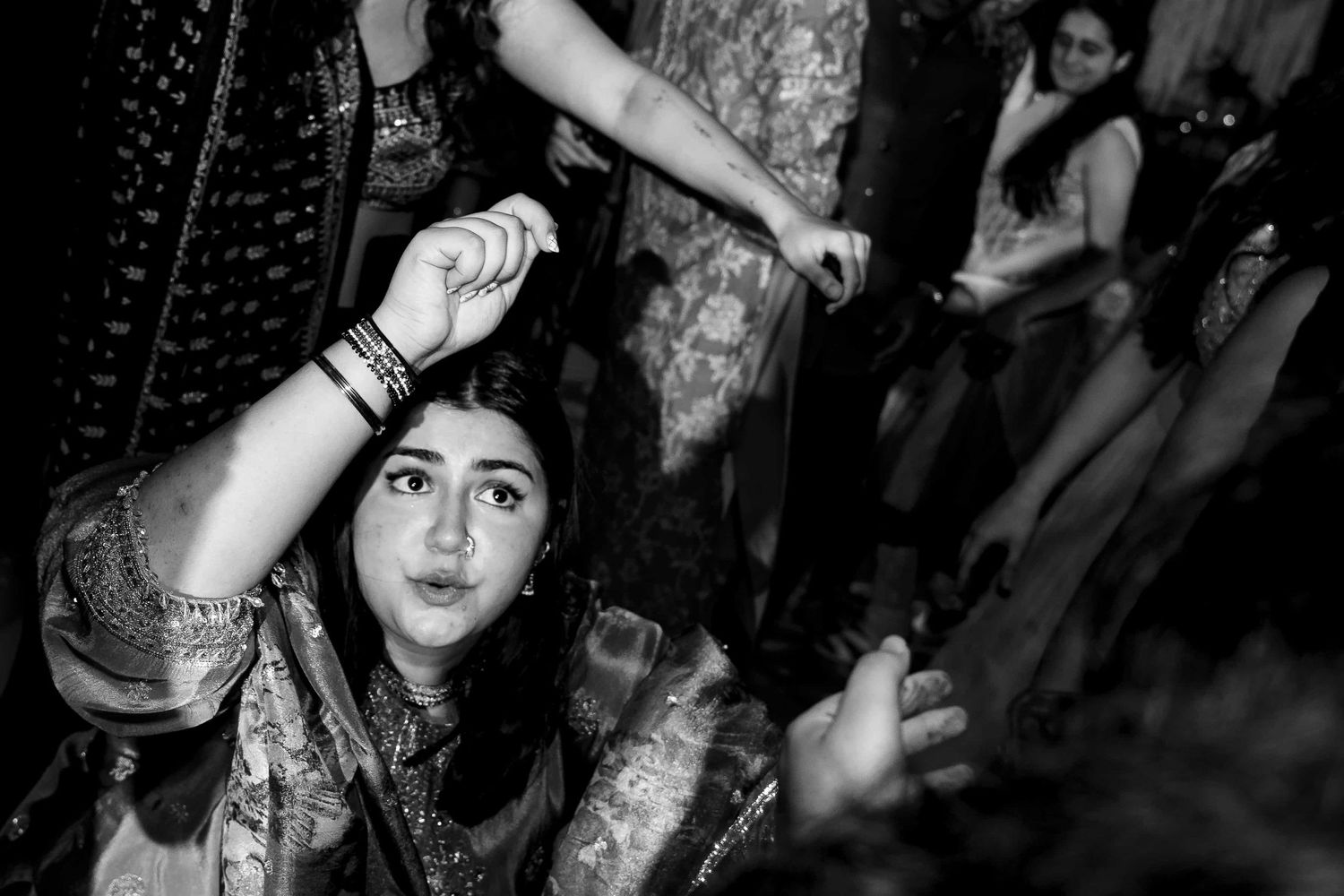 A black and white photo captures the energy of traditional Indian dance movements.