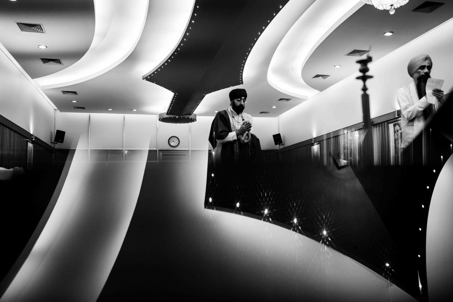 Black and white architectural photo showing curved lines and silhouettes in modern interior space.