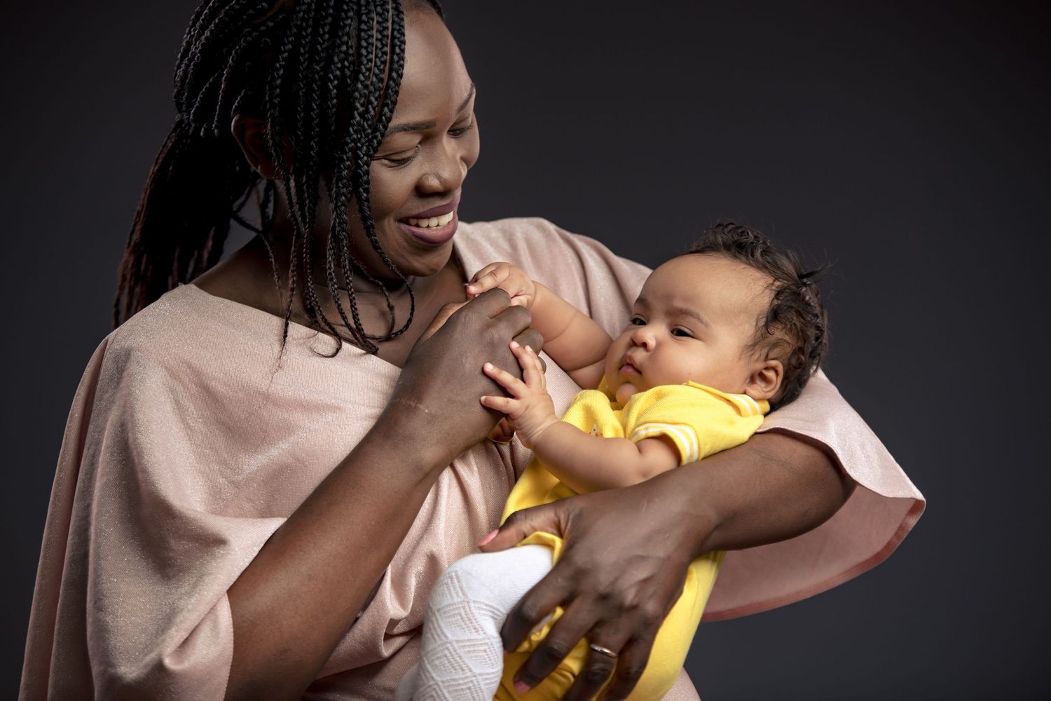 Series of intimate black and white photos showing tender moments between parent and infant.