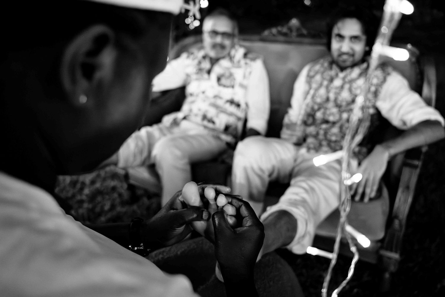 Black and white photo of guests dancing and celebrating at a festive wedding reception.