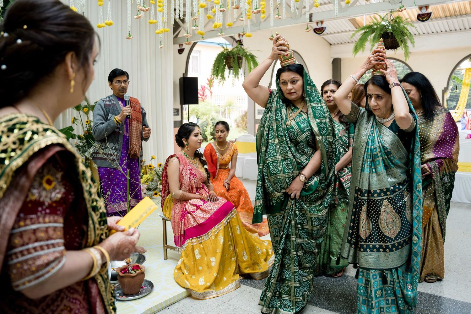 Women in vibrant saris dancing and celebrating during an Indian wedding ceremony.