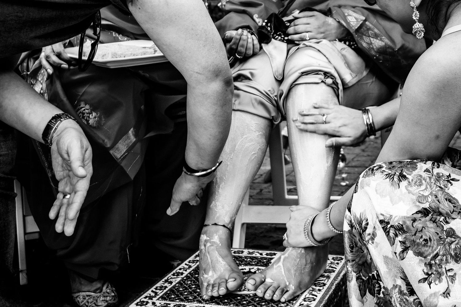 Black and white image of hands preparing food and drinks at an event.
