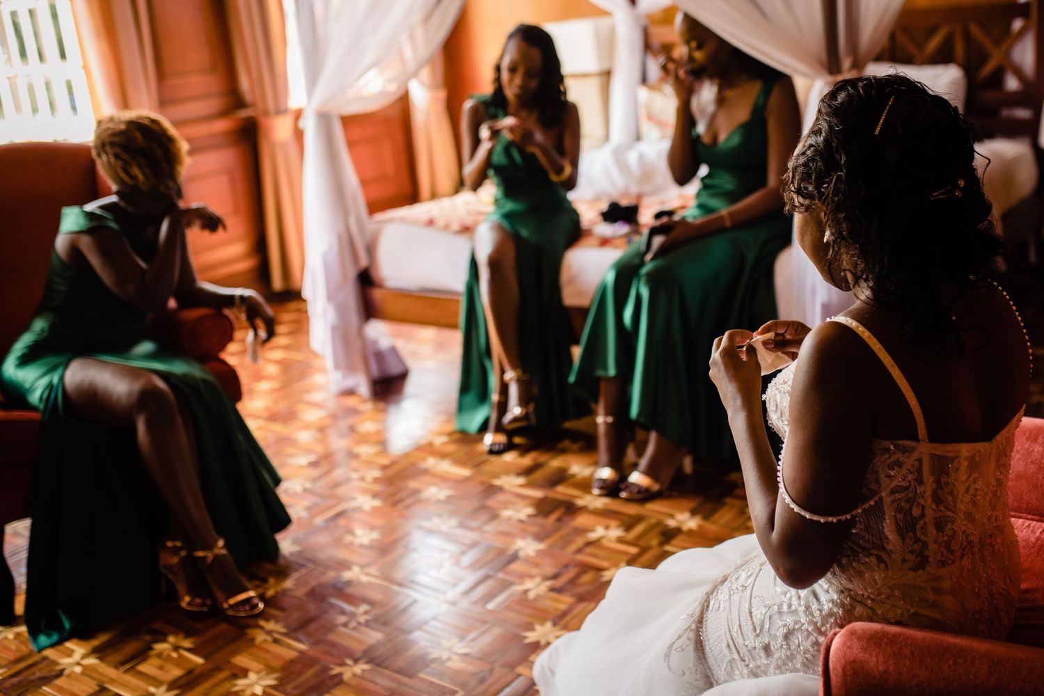 Wedding reception scene with guests in green dresses dancing on a warm-toned dance floor.