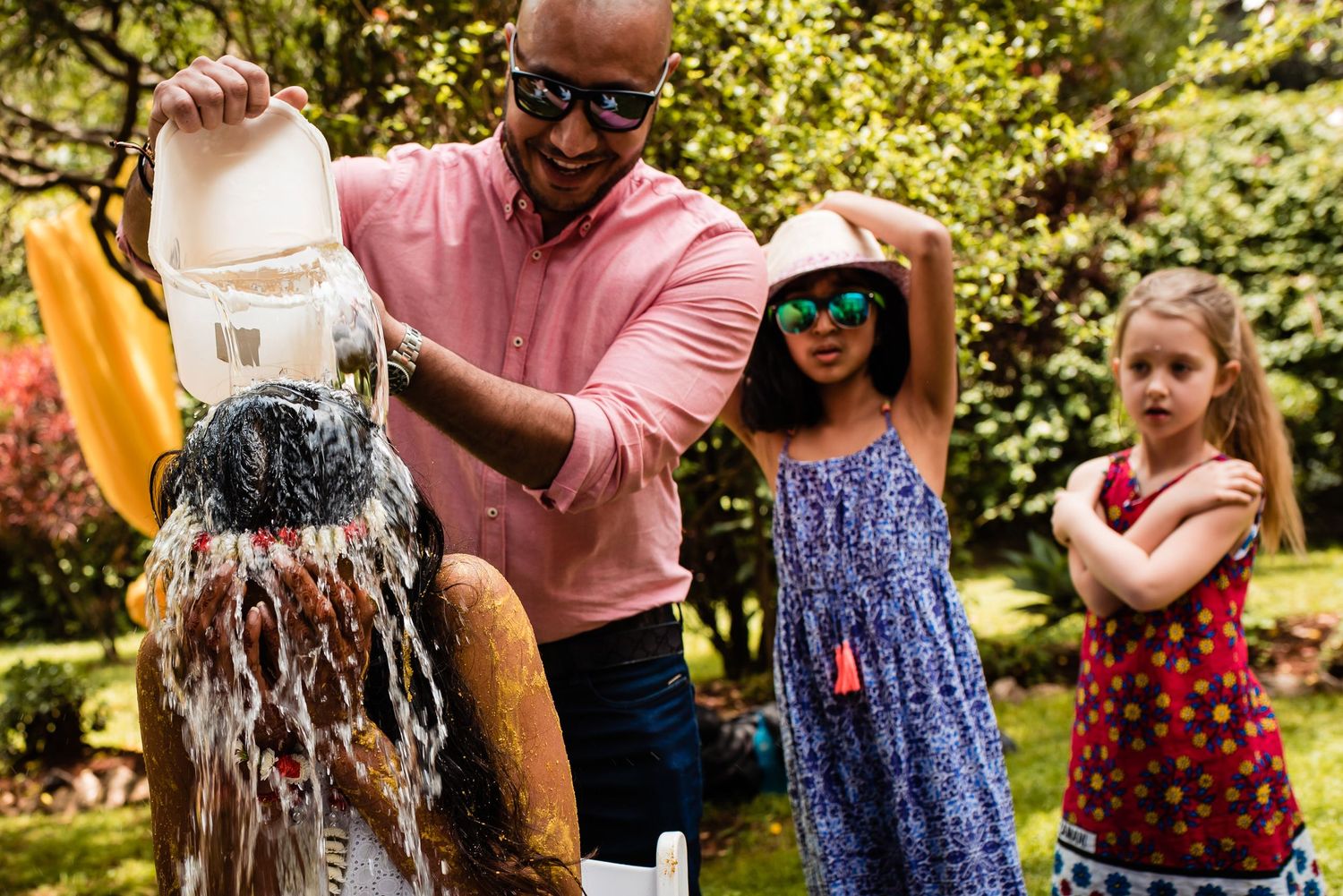 People playing with water and splashing outdoors during a festive summer celebration.