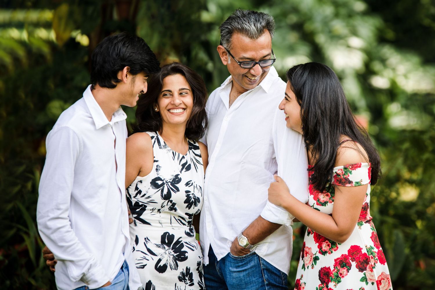 Outdoor family photoshoot with natural lighting showing genuine smiles and interactions.