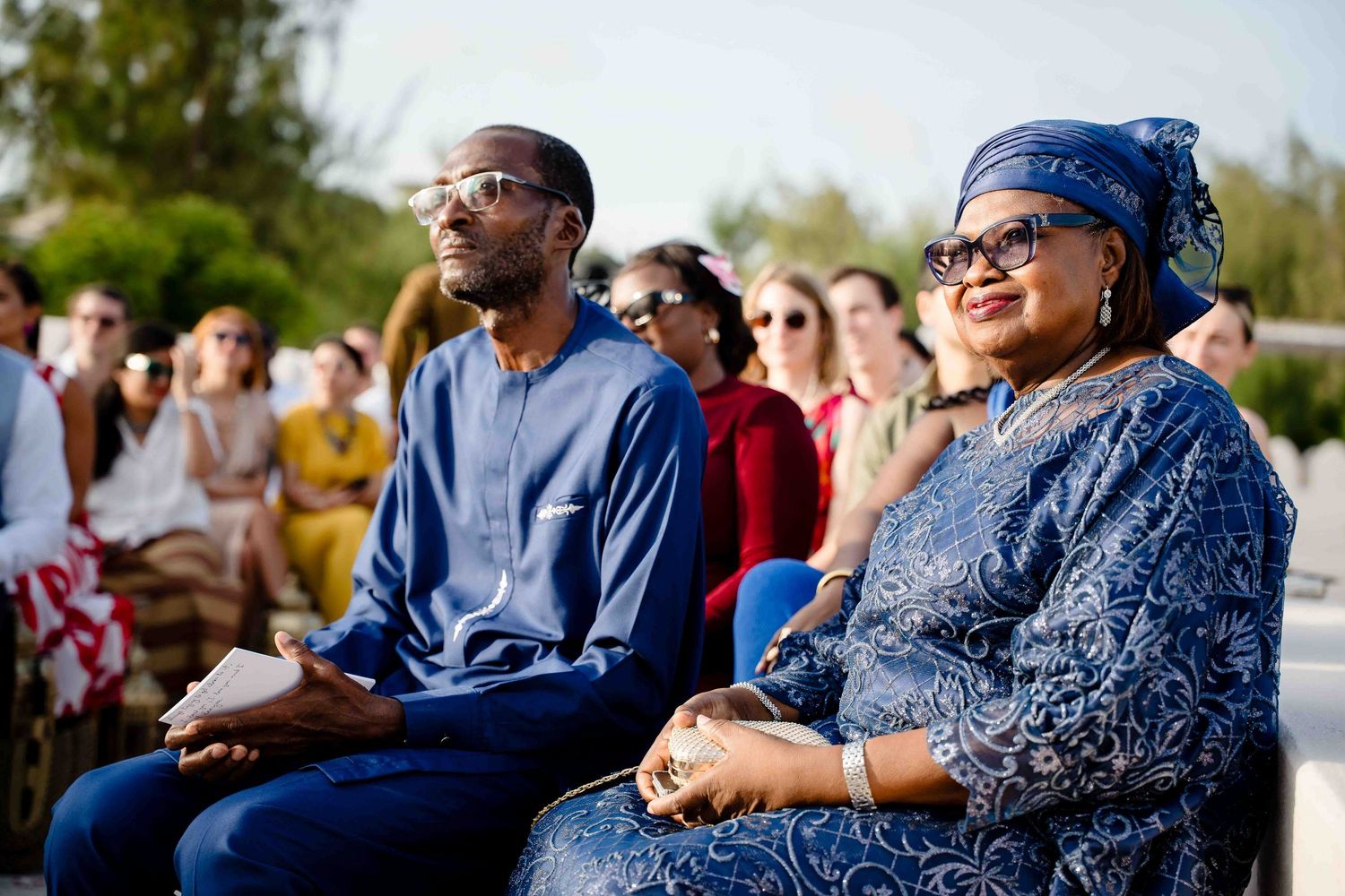 A group of people in blue attire enjoying an outdoor gathering on a sunny day.