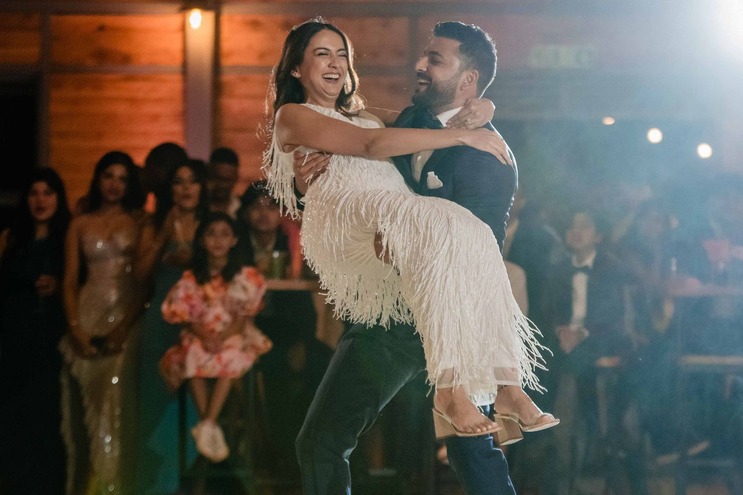 A couple performs a romantic dance move during their wedding celebration.