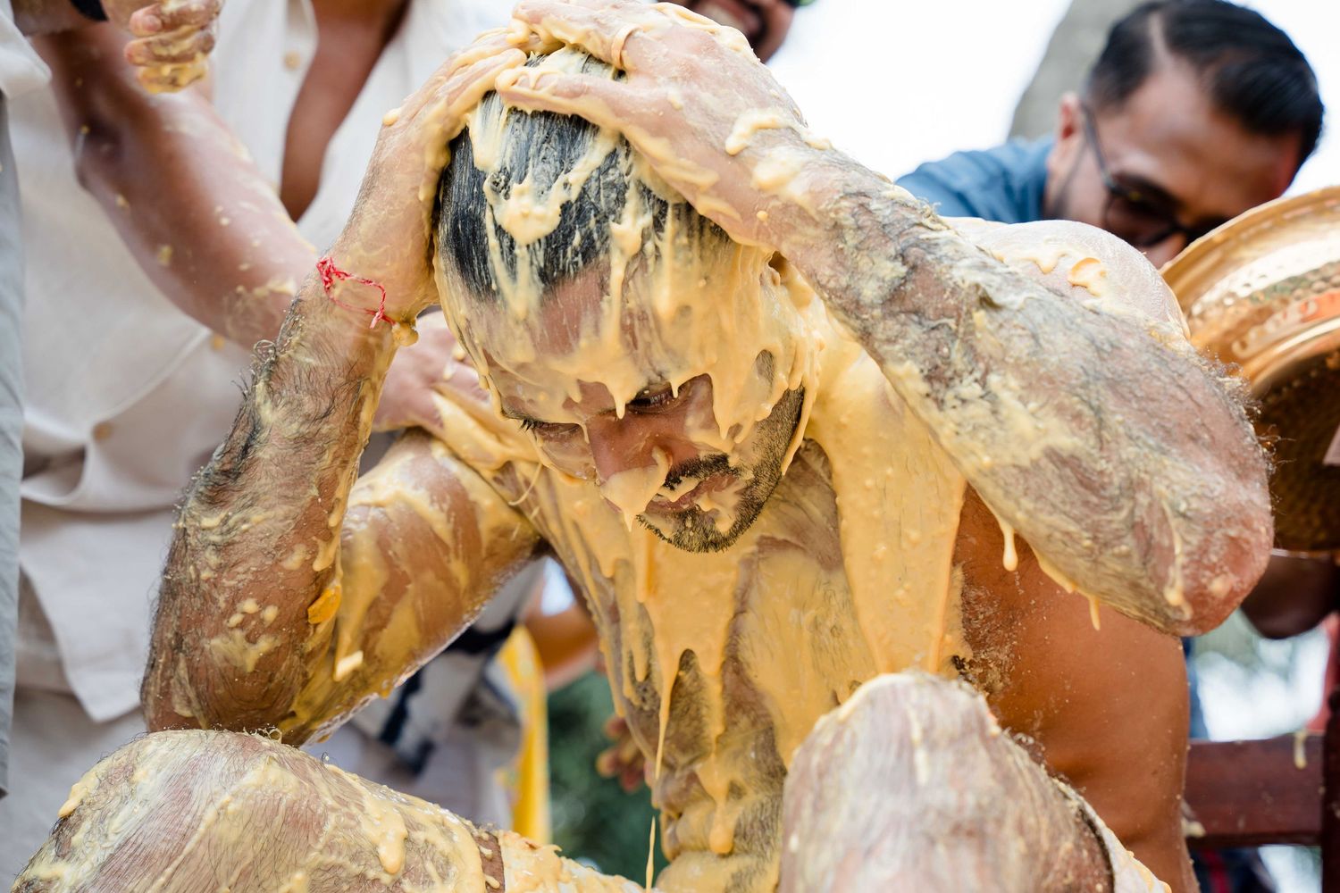 Wedding guests dance and celebrate with gold confetti falling during a lively reception party.