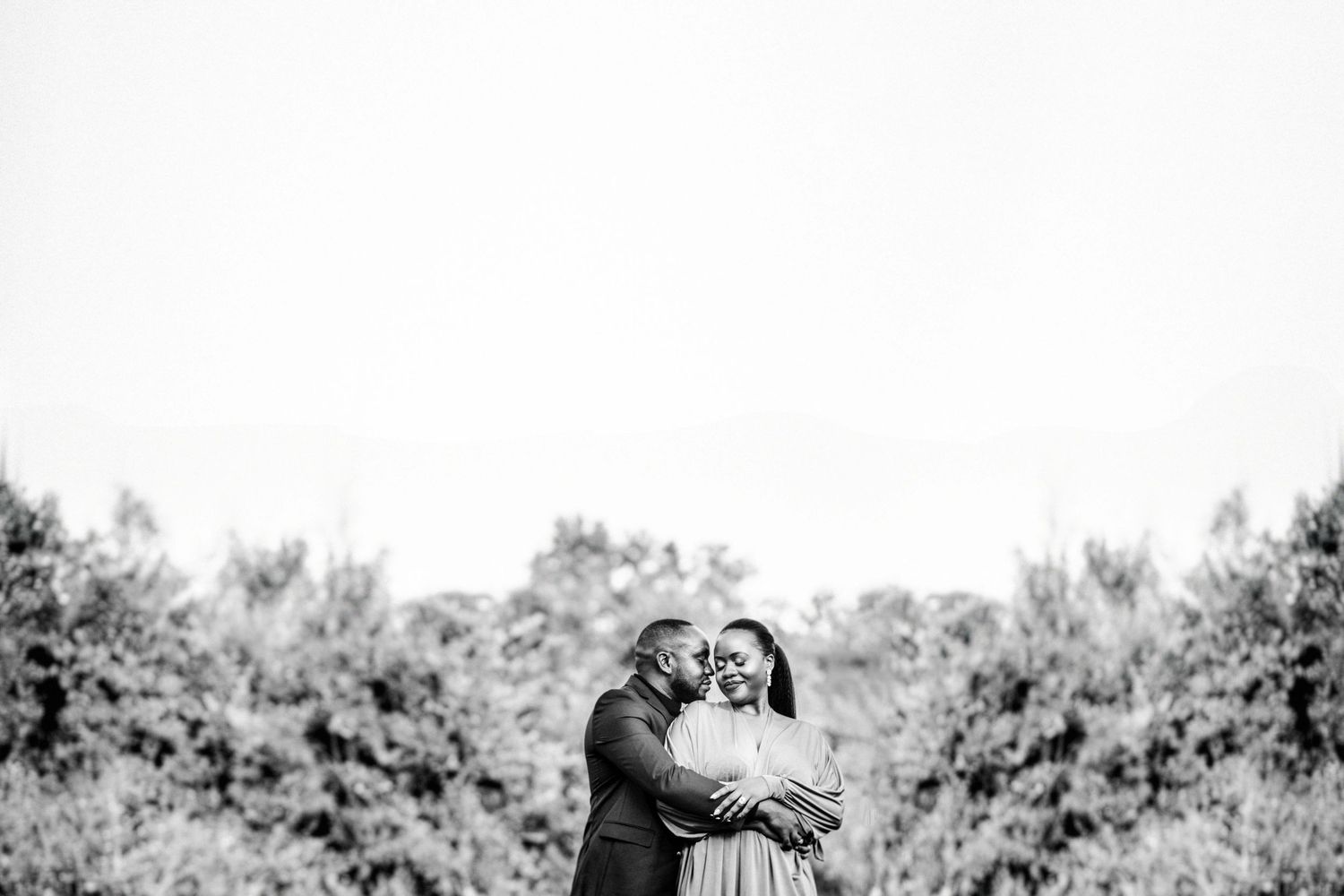 Wedding couple poses in bright white outdoor setting with natural lighting.