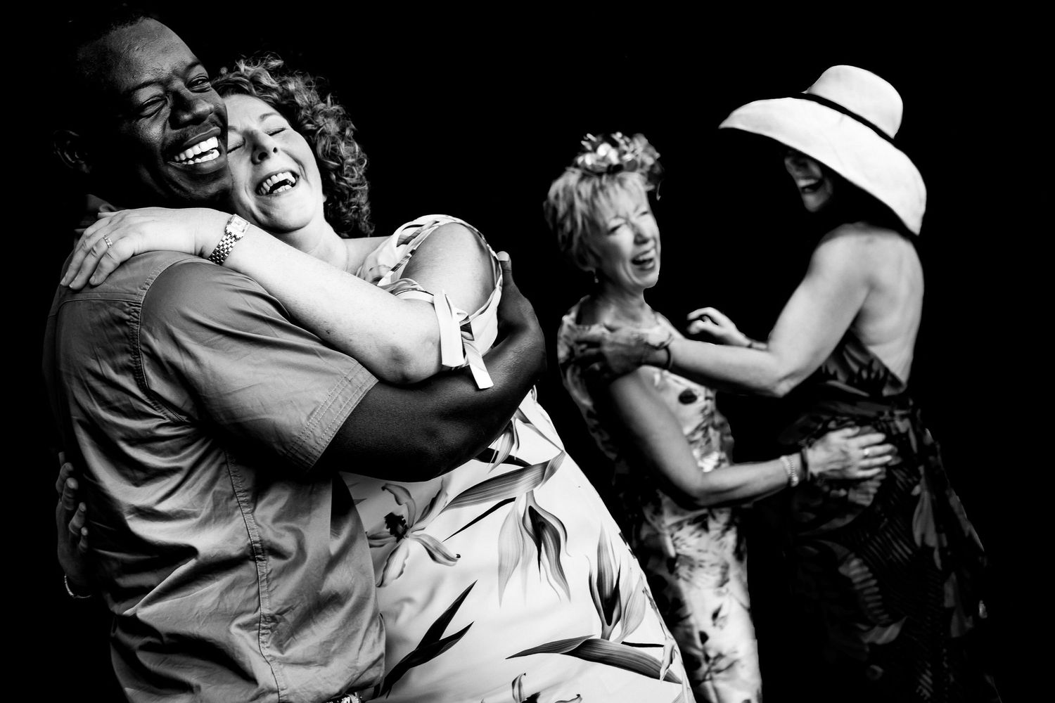 Dramatic black and white shots of people dancing and celebrating at a lively party.