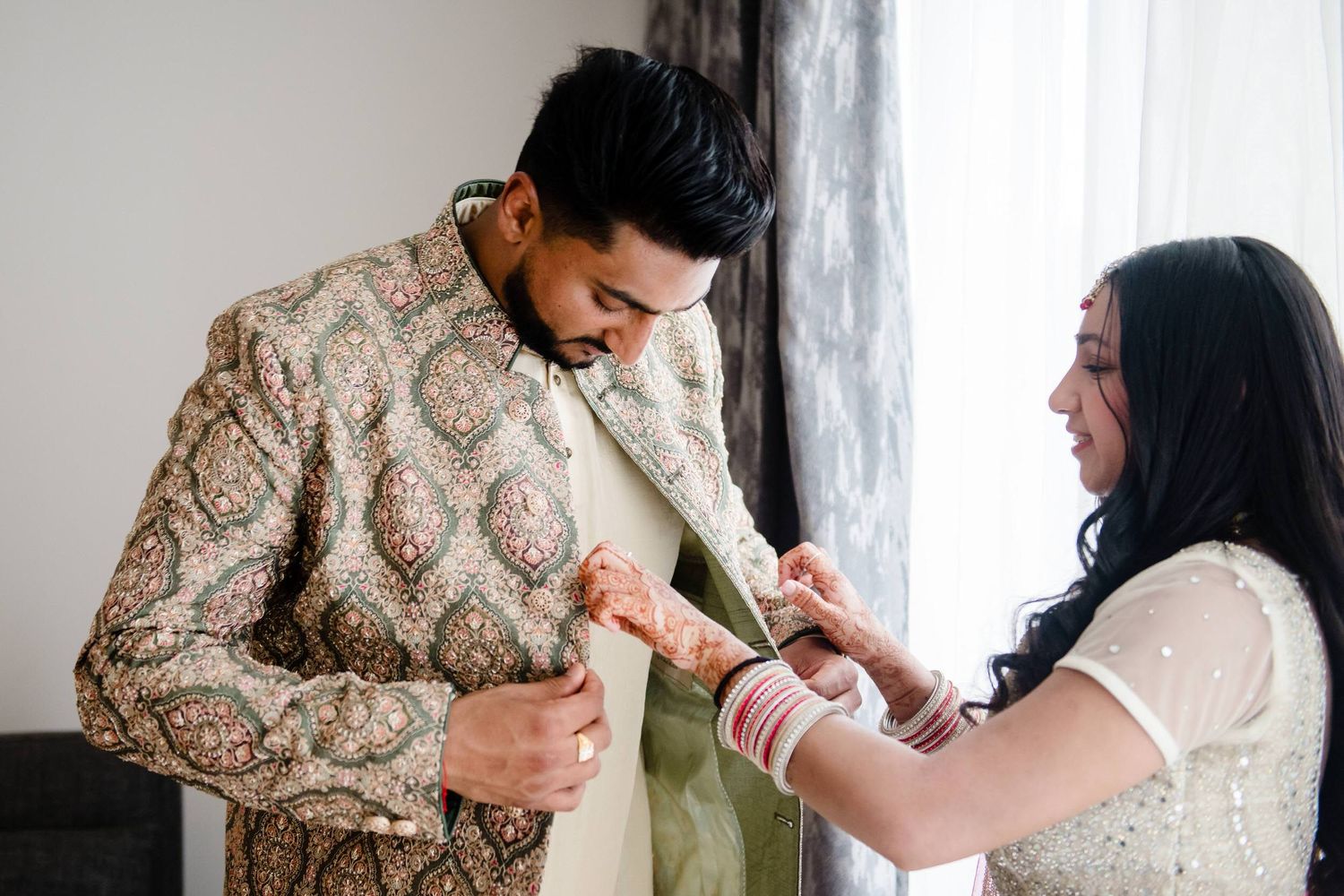 Traditional Indian wedding ceremony with couple performing rituals in elegant gold and cream outfits.