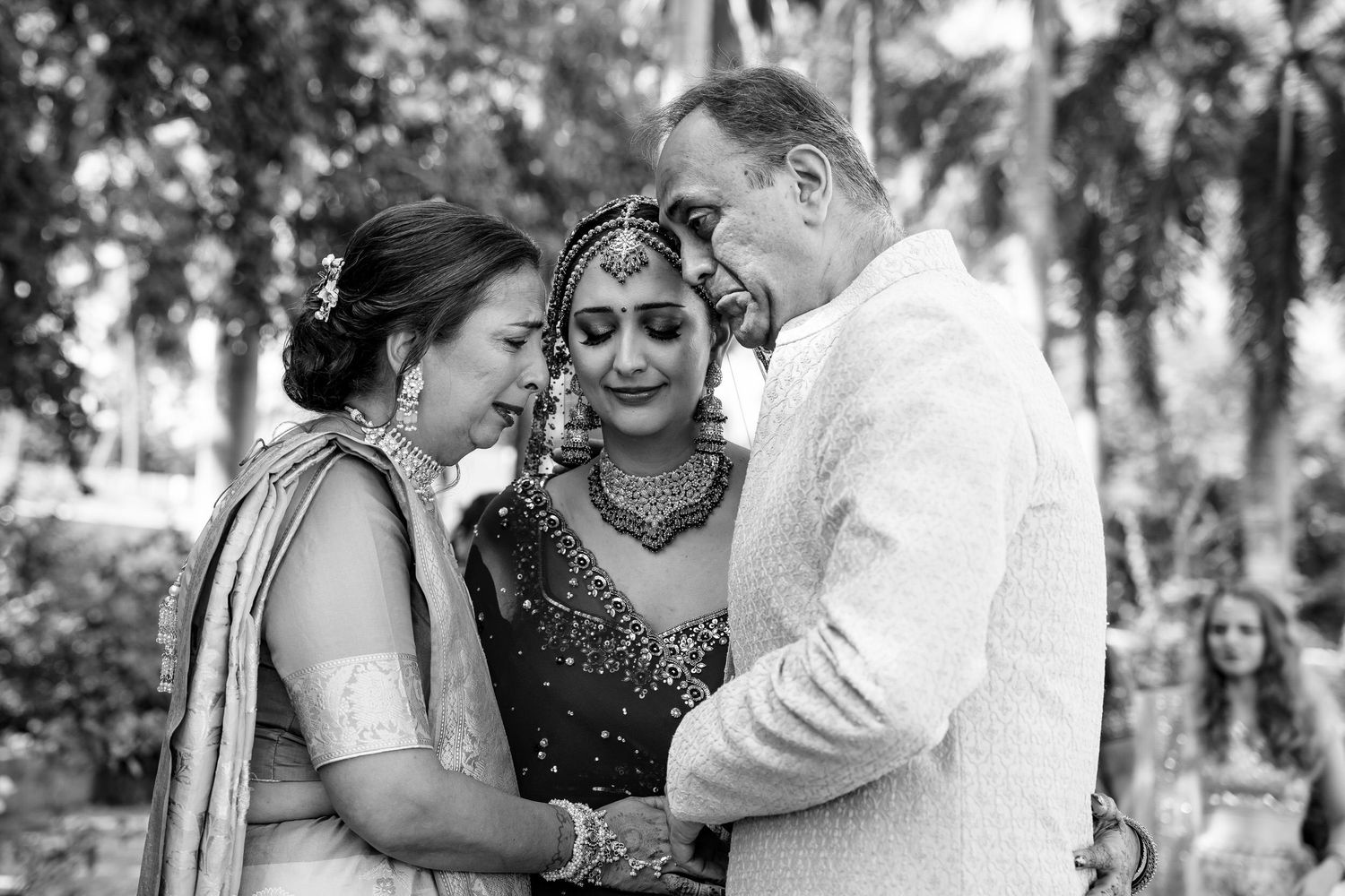 Black and white wedding photos showing joyful moments between couples dancing and embracing in an outdoor garden setting.