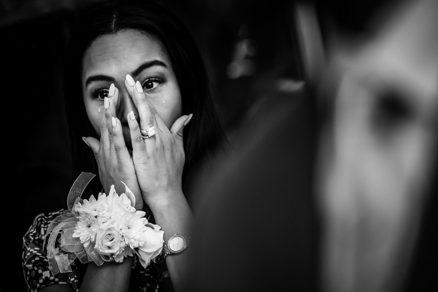 Dramatic black and white portrait of an emotional bride with white flowers.