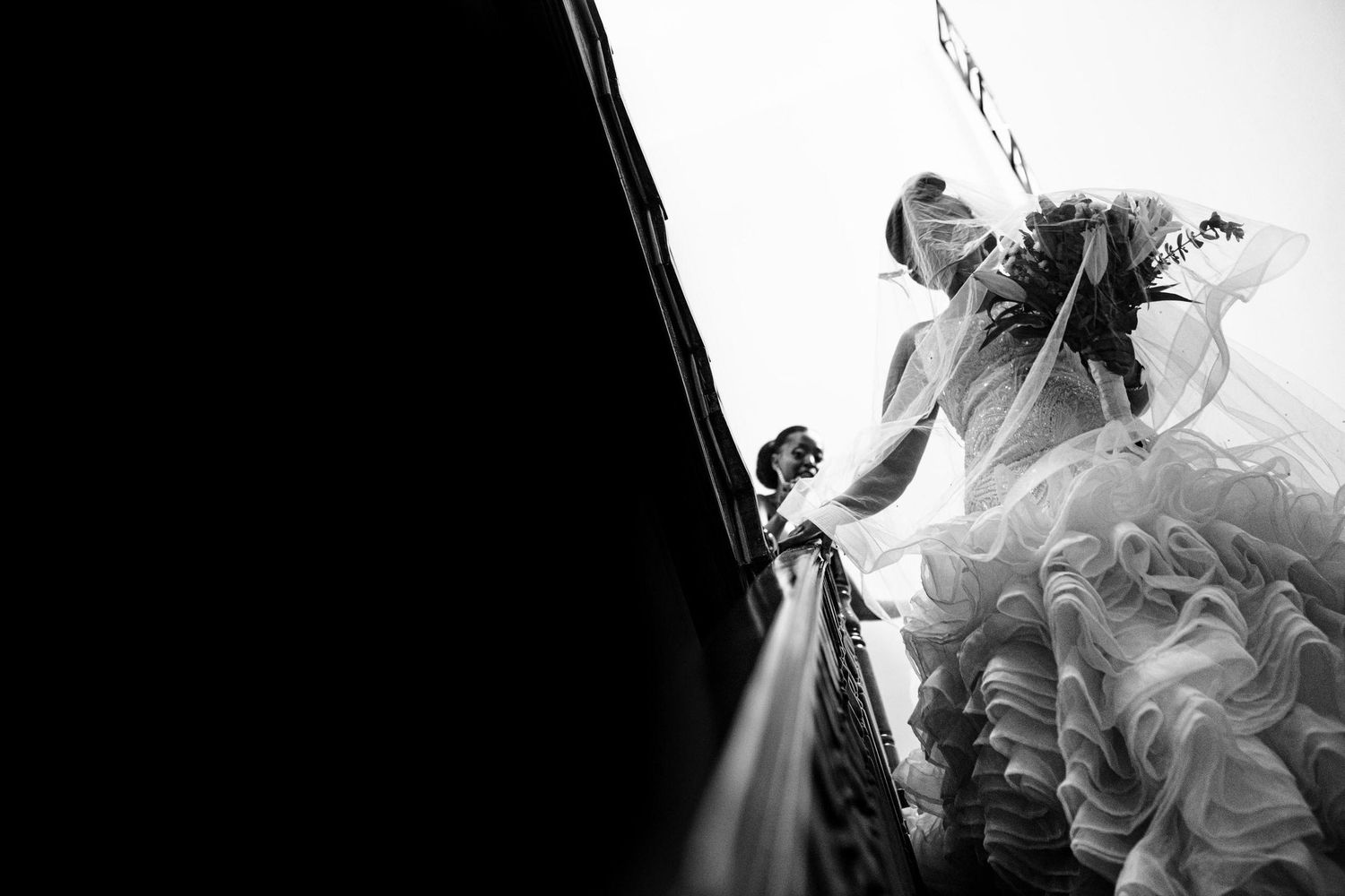 Black and white wedding photography captures dramatic silhouettes and veil details during an emotional ceremony.