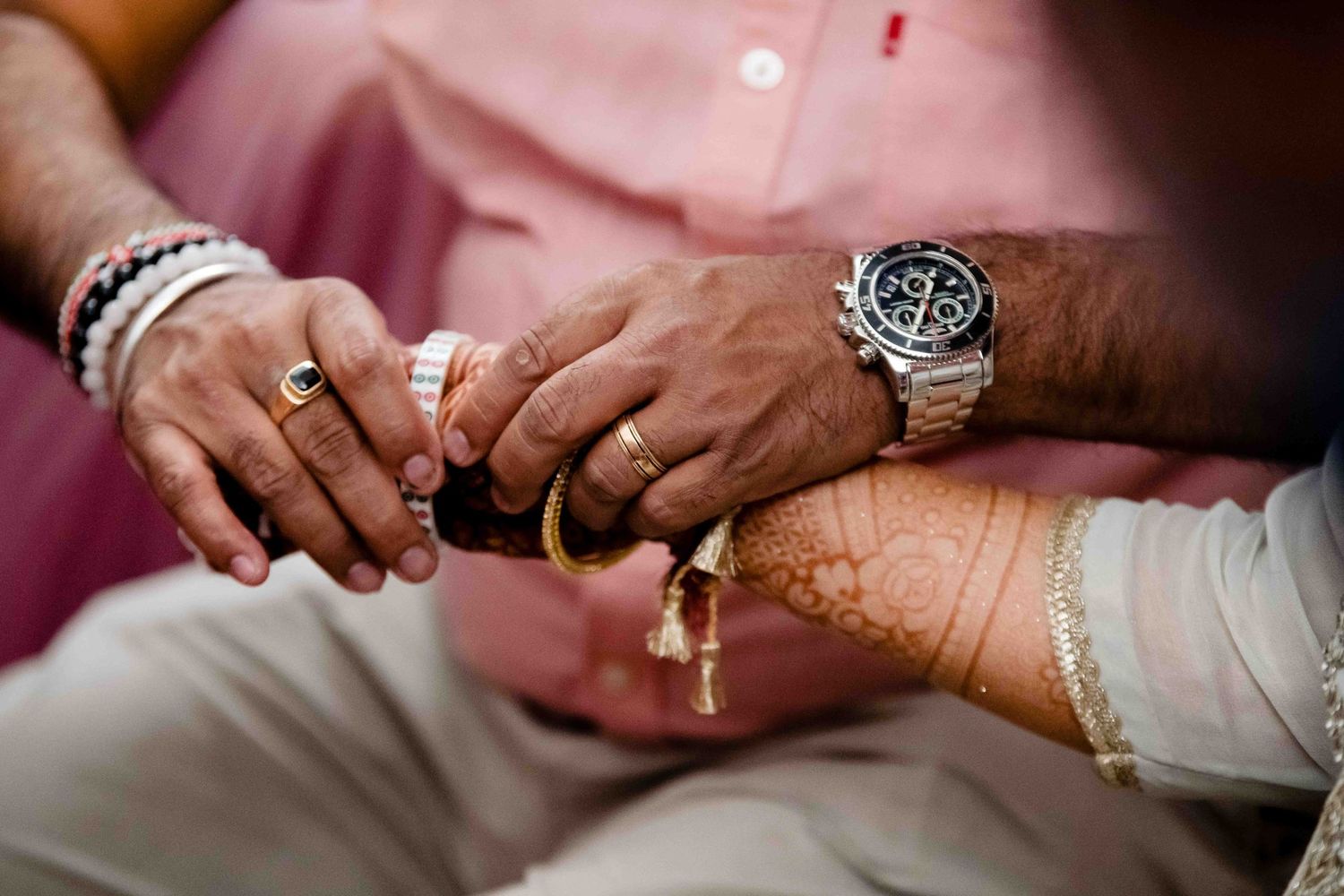 Close-up of hands exchanging rings during traditional wedding ceremony.