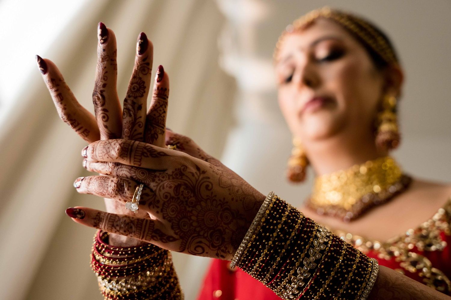 A person in traditional Indian attire performs an expressive dance move with graceful hand gestures.