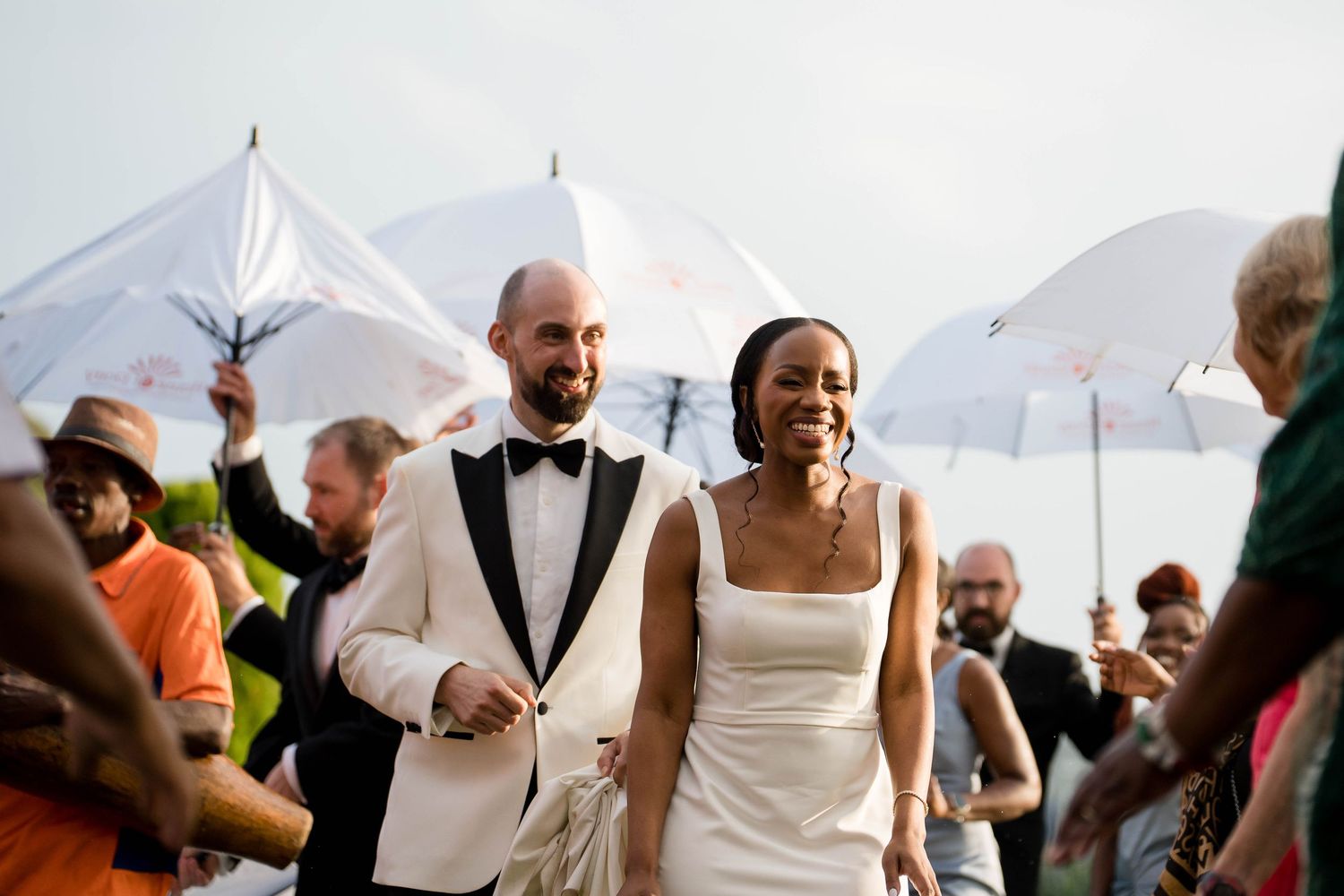 Wedding guests dance and celebrate together on an outdoor dance floor during a reception party.