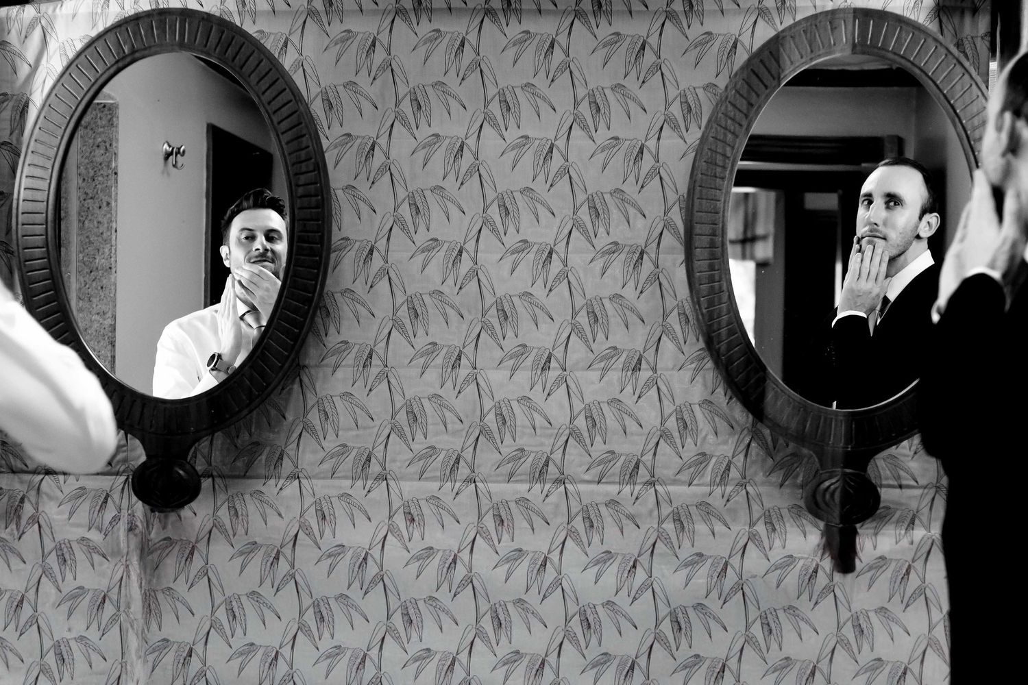 Creative black and white portrait of someone looking in two circular mirrors.