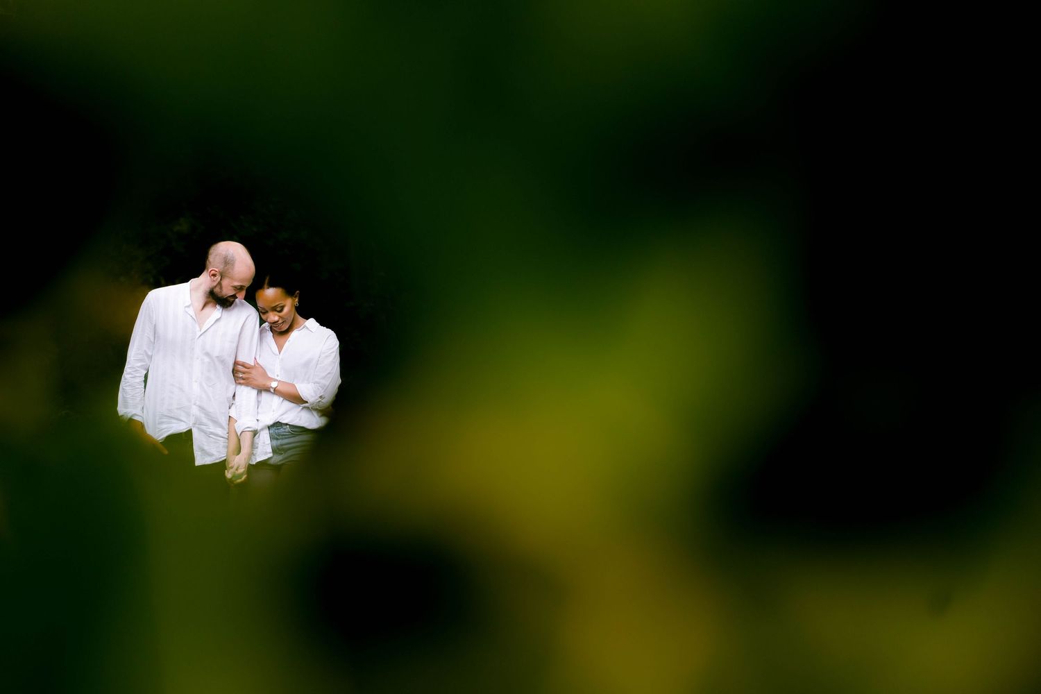 Intimate couple sharing a tender moment together in soft natural lighting outdoors.
