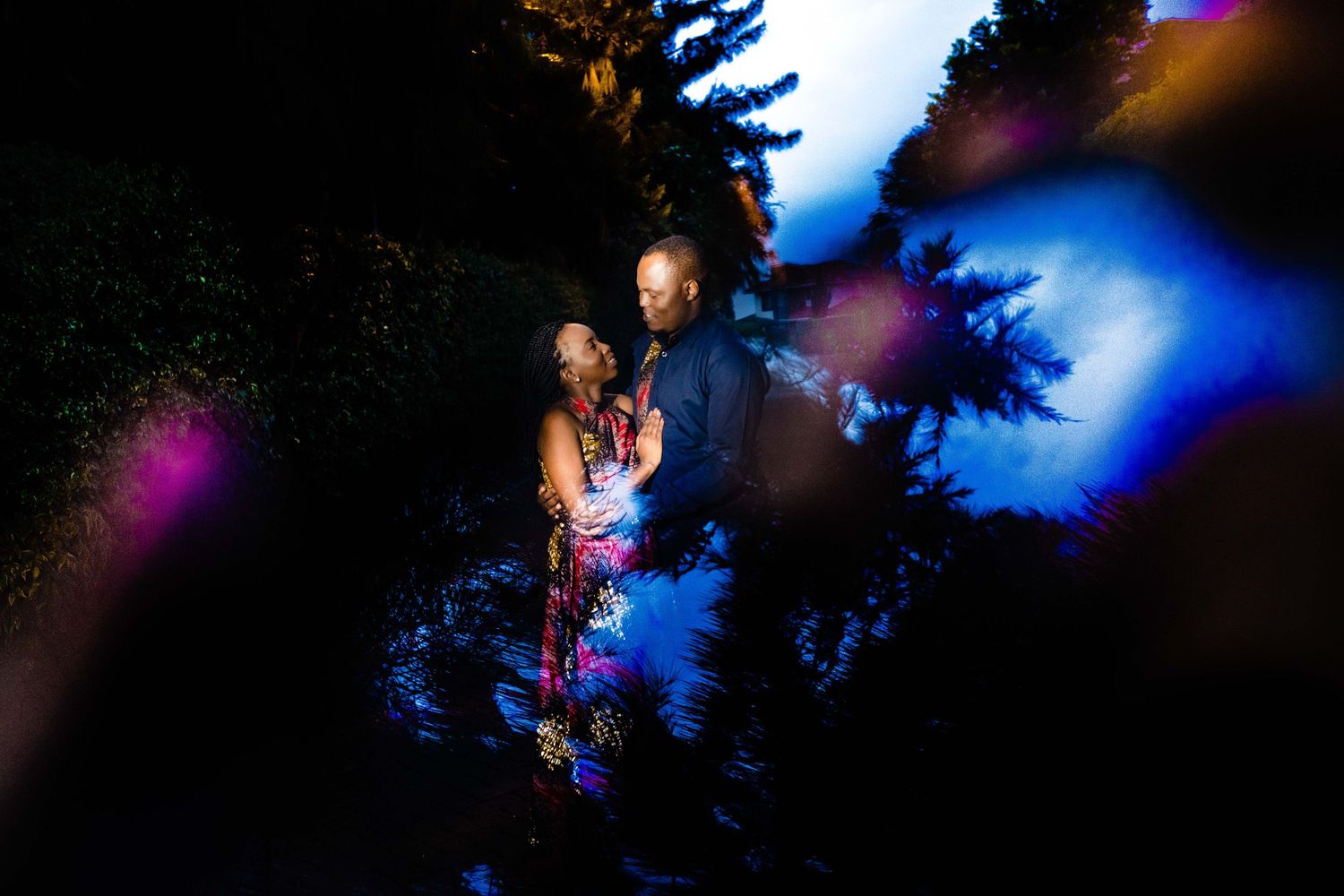 A wedding couple dances under dramatic blue and purple lighting during their first dance.