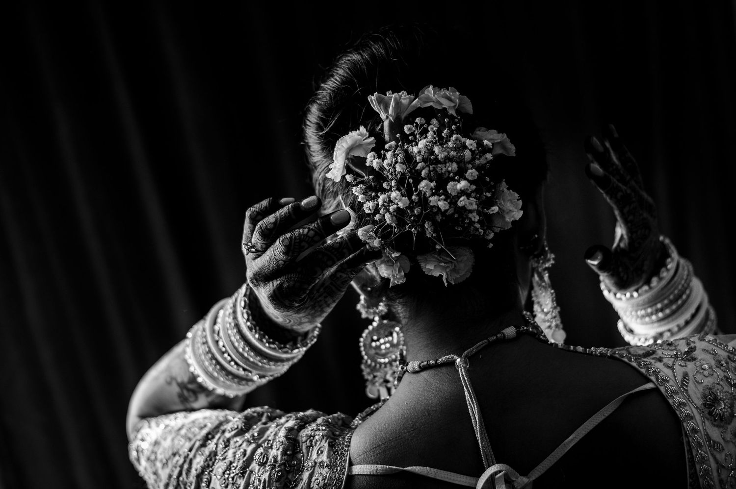 Black and white image showing detailed wedding jewelry and hair accessories being arranged.