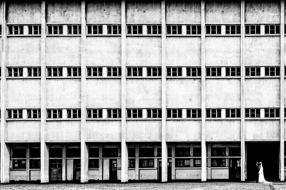 Long architectural facade of modernist building with repetitive window pattern in black and white.