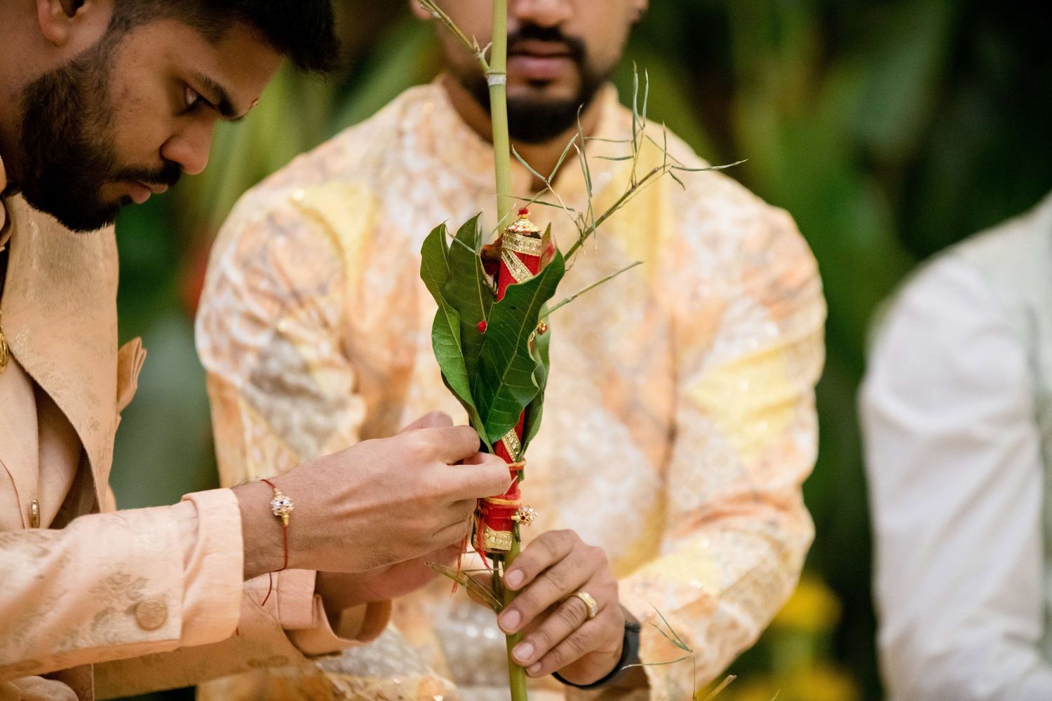 Close-up of traditional Indian wedding ritual with betel leaves and decorative elements.