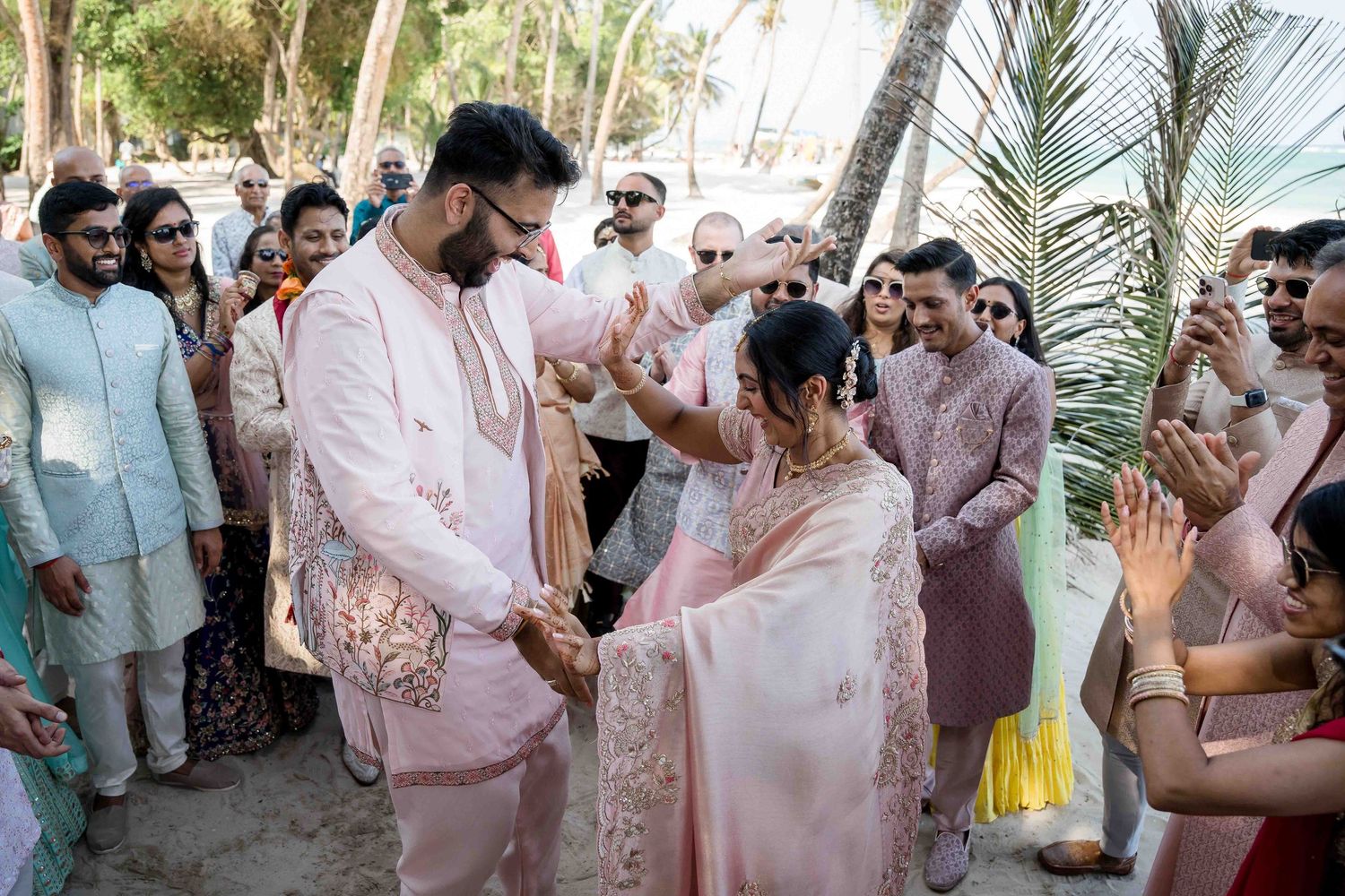 Guests celebrate at an outdoor garden party with palm trees and festive decorations.