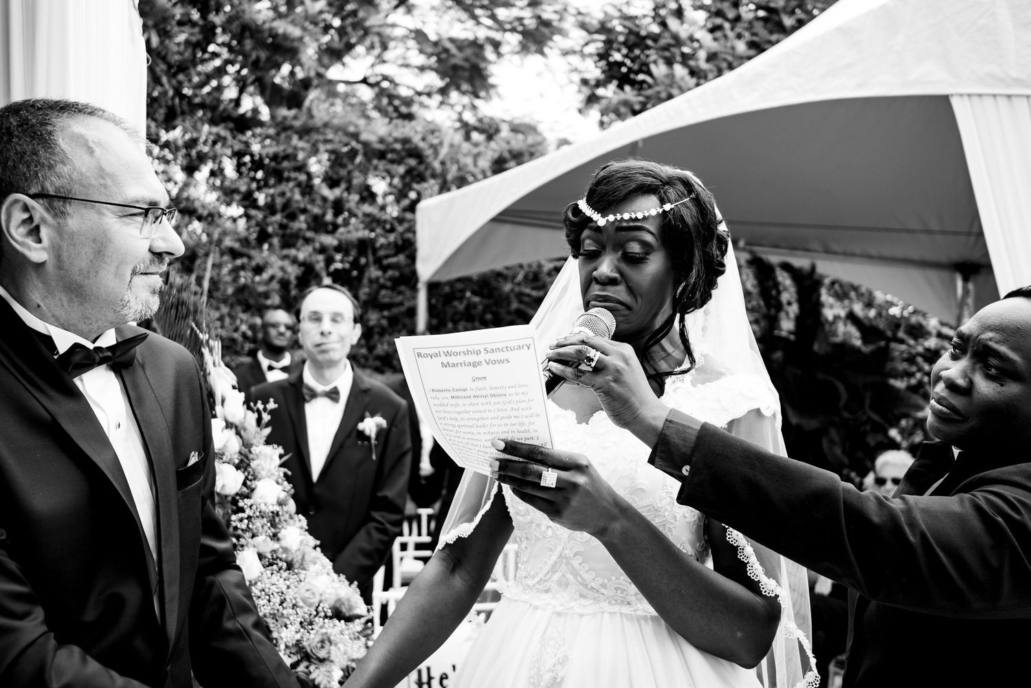 Wedding guests raise champagne glasses in an outdoor toast celebration.