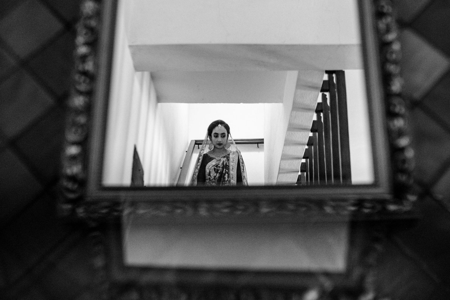 Minimalist architectural framing of a wedding scene through multiple doorways and windows.