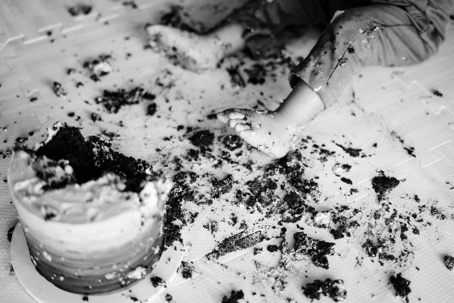A close-up sequence showing chocolate cookie crumbs being crushed and scattered on a white surface.