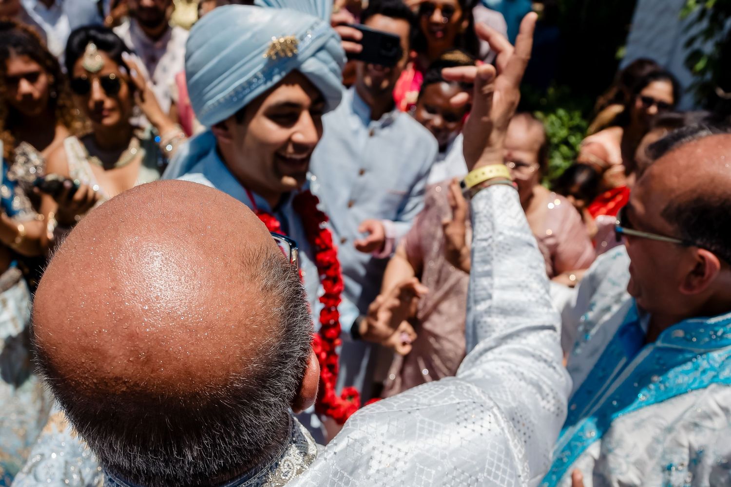 Traditional cultural celebration with guests gathering outdoors under bright blue skies.