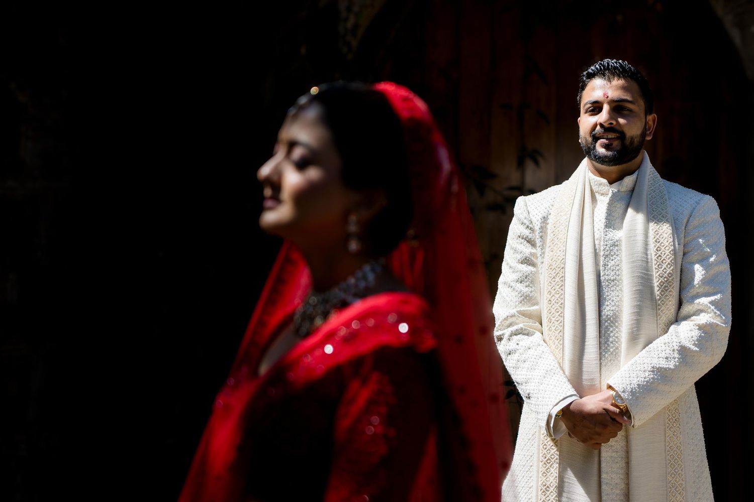 A dramatic wedding portrait with contrasting light and shadow.